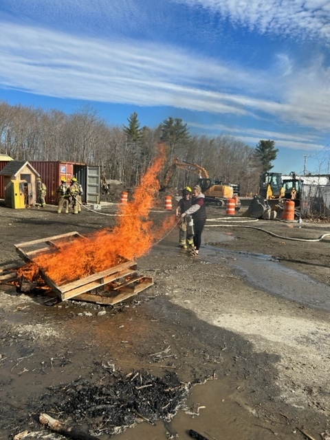 Med Occ and Firefighting students using a fire extinguisher 
